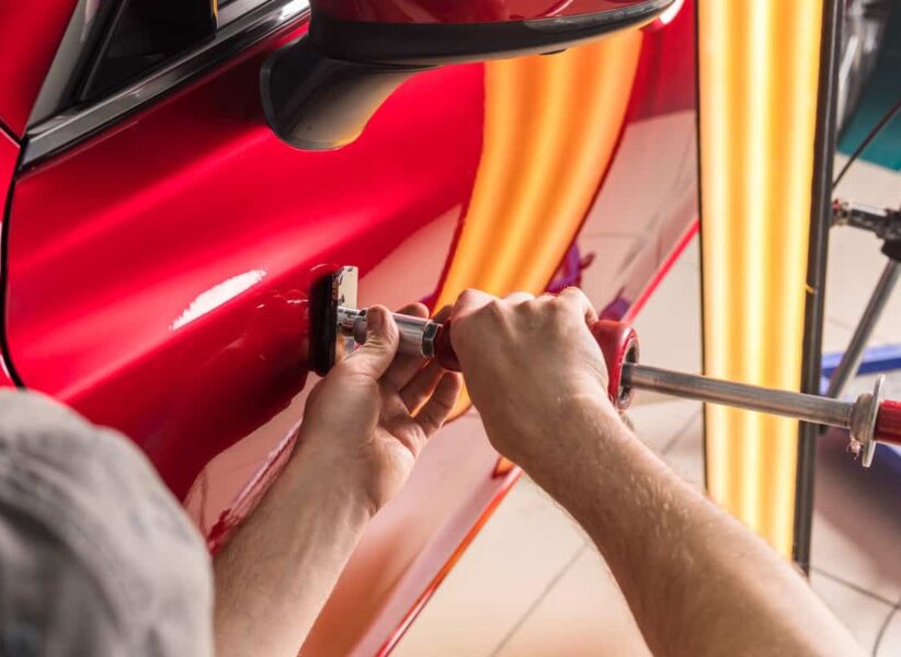 A-technician-fixing-a-dent-on-the-car-door-siding